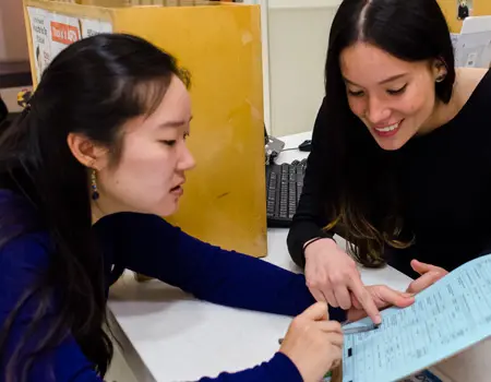 a shelter worker goes over paperwork with adopter